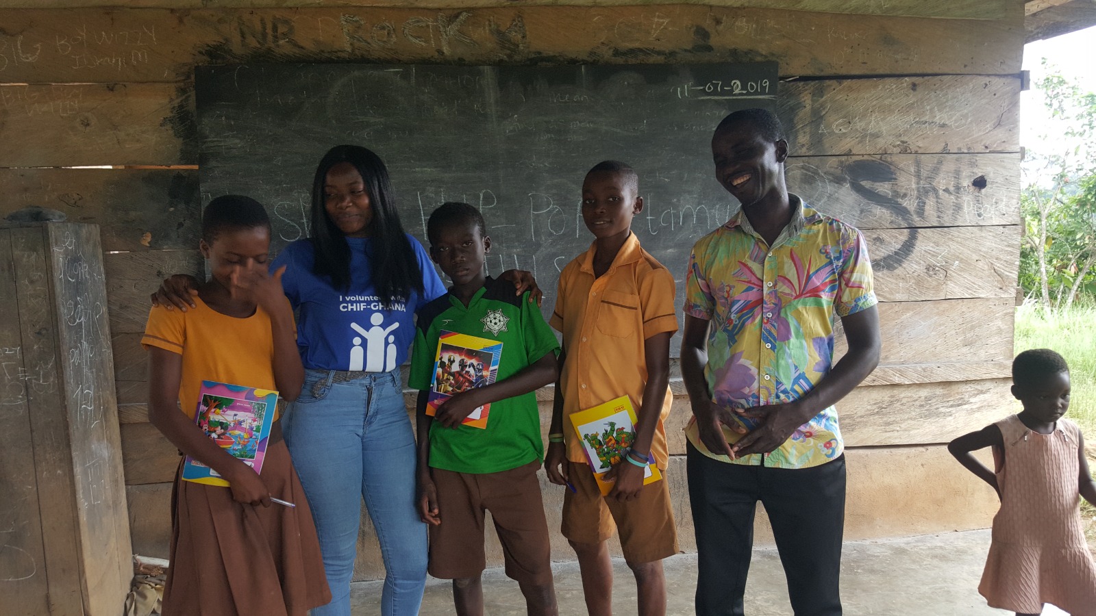 Volunteer and students holding new textbooks together