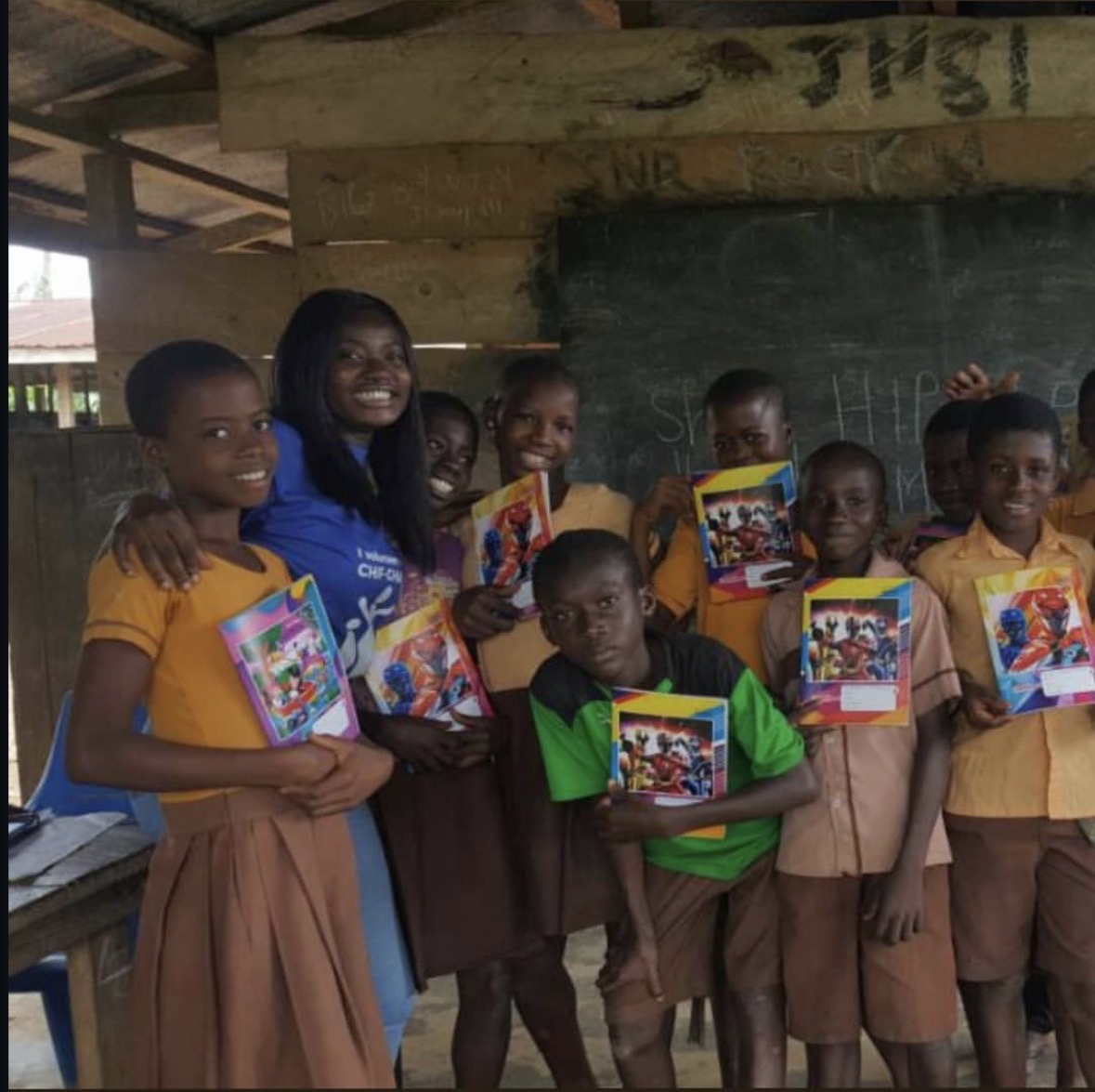 Students proudly showing their new books with a volunteer