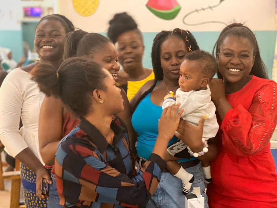 Volunteers gathered around a mother holding her baby